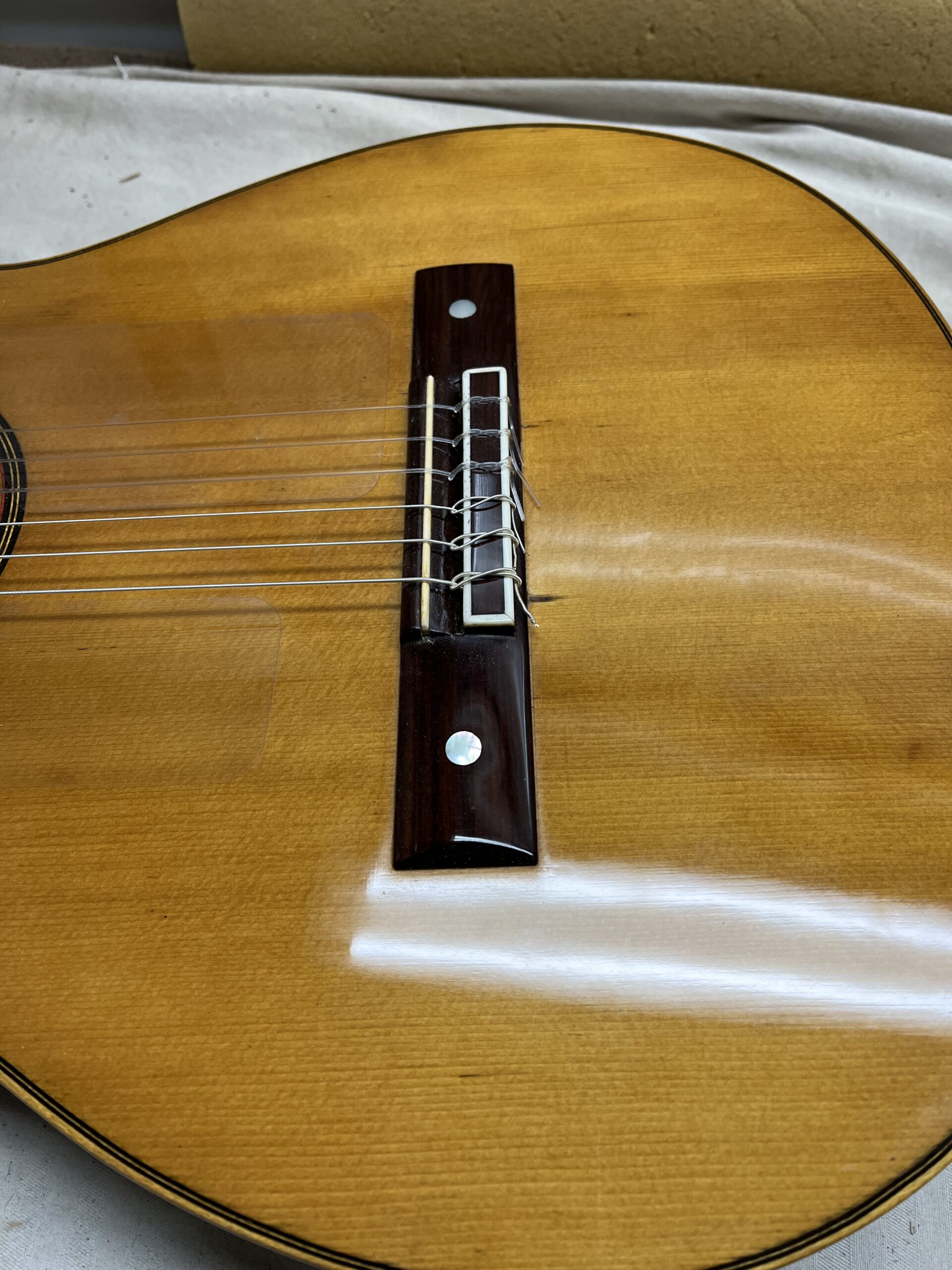 Guitar bridge with two small mother-of-pearl ornaments
