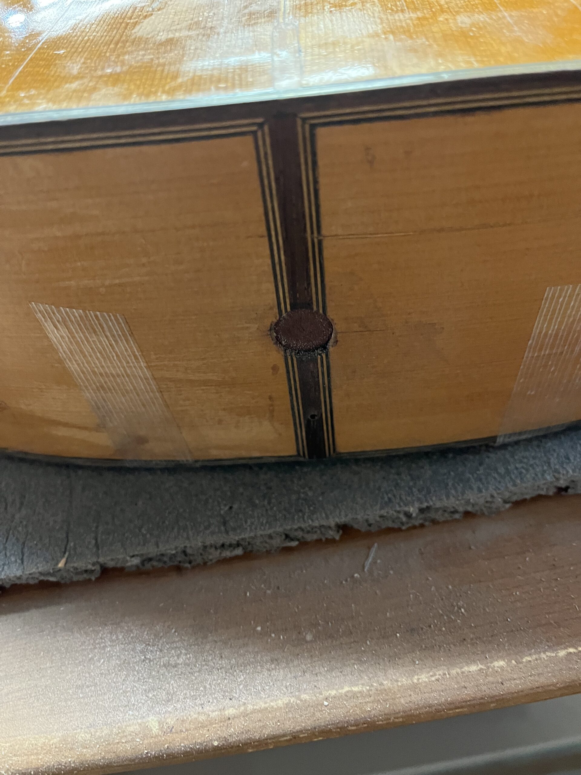 Later hole passing through the decorative strip at the tail of the guitar