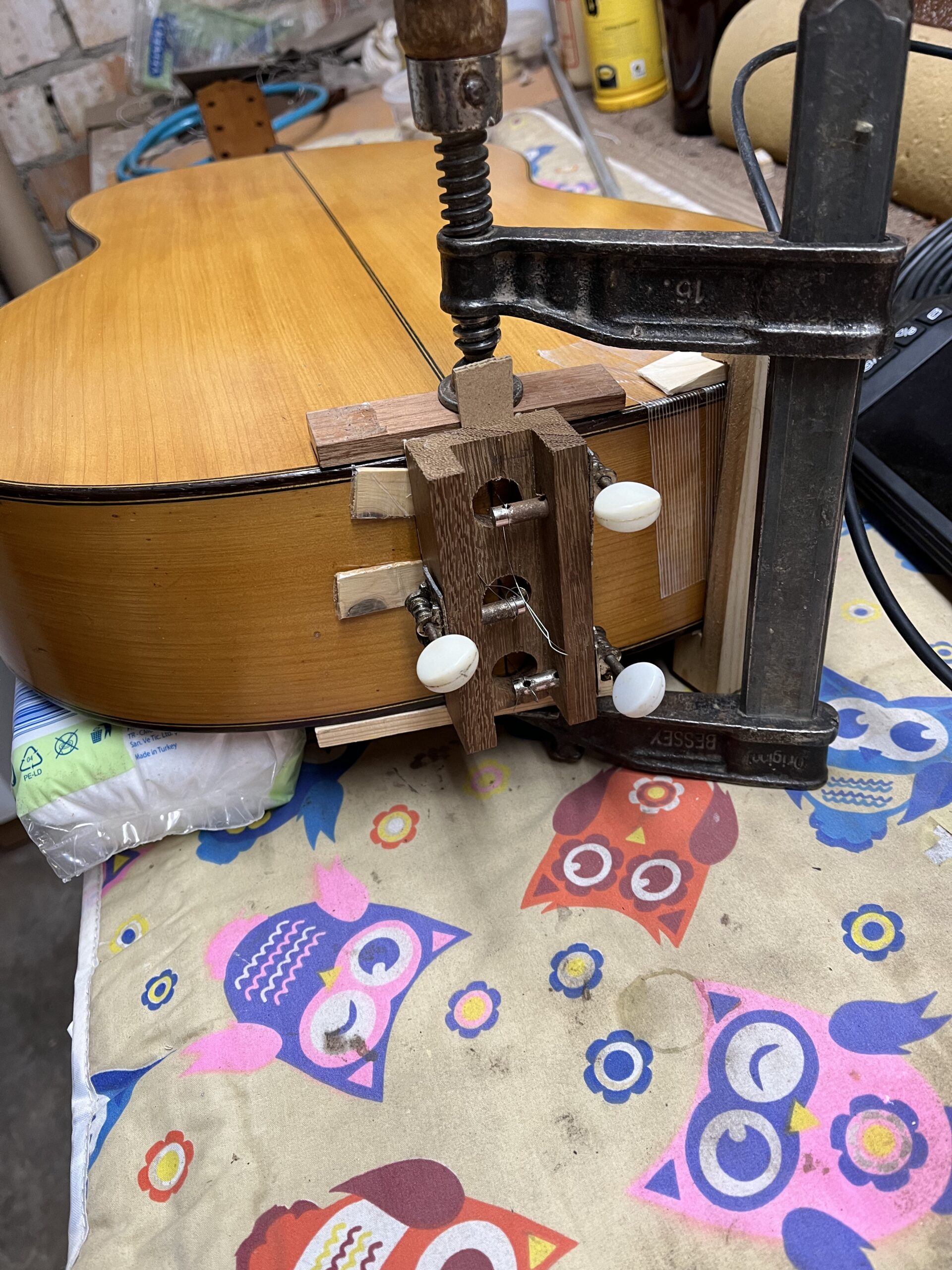 Sistema con cuerda y clavijero de bandurria para reparar la culata de una guitarra flamenca